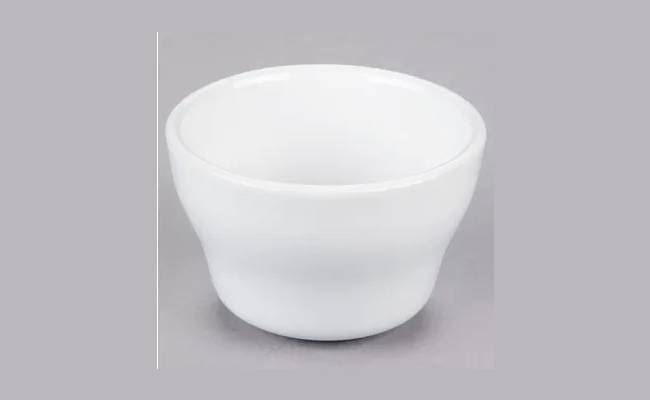 A plain white ceramic bowl centered on a light grey background.